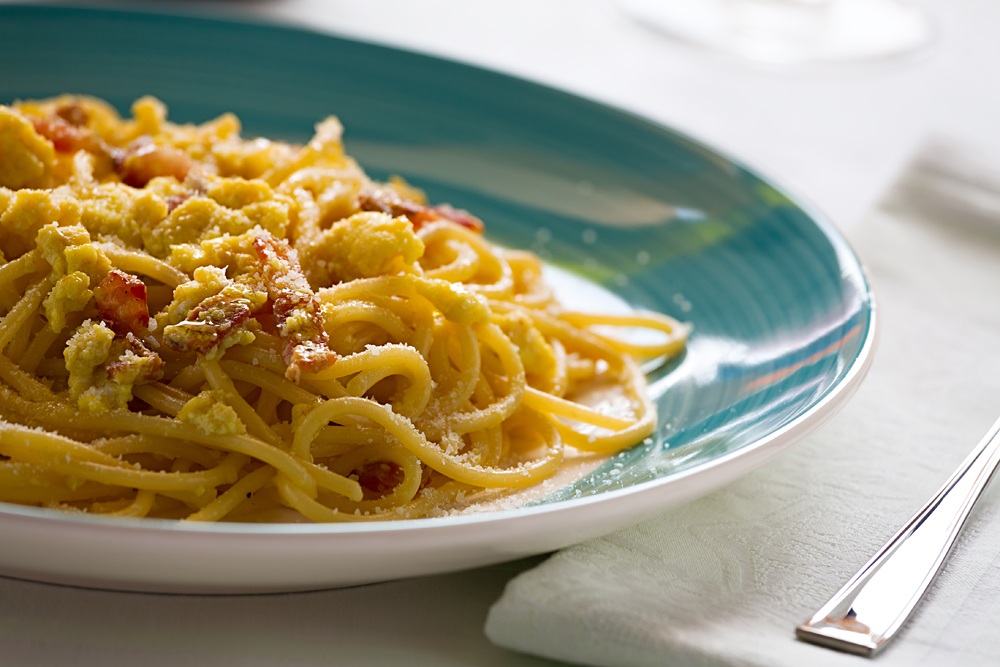 Spaghetti-carbonara-with-egg-smoked-bacon-and-cheese-over-a-table_708000757